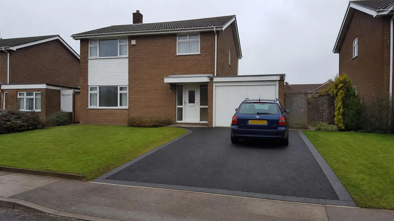 1970s detached house with a tarmac drive, block border and open-plan lawn