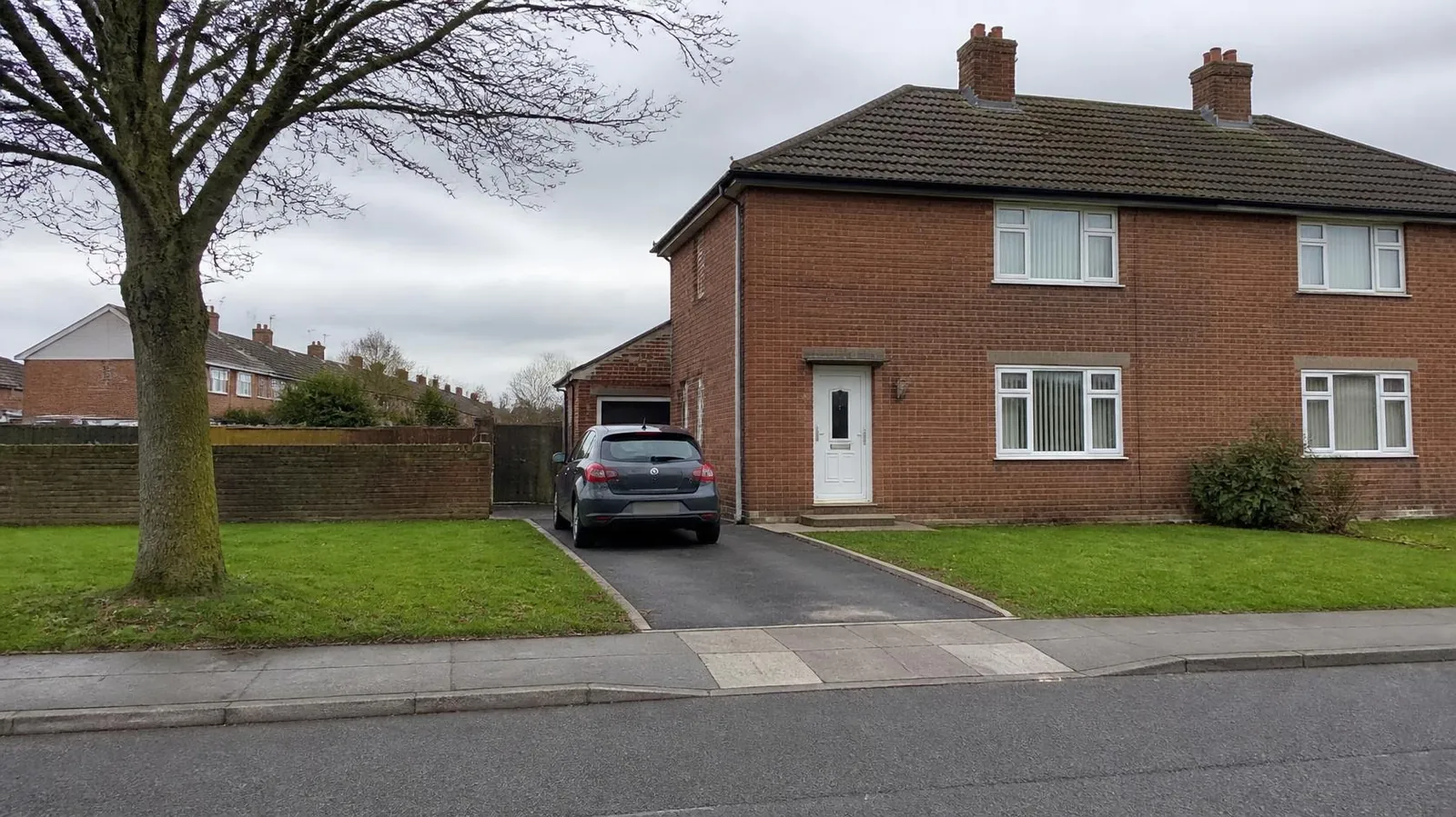 1950s brick semi with a tarmac driveway where the front lawn used to be